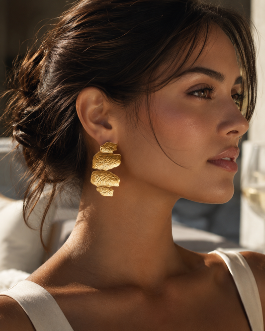 Abstract gold statement earrings with an organic hammered texture and layered drop design in a polished gold-tone finish, perfect for quiet luxury wardrobes, modern fashion, special occasions and contemporary everyday styling.