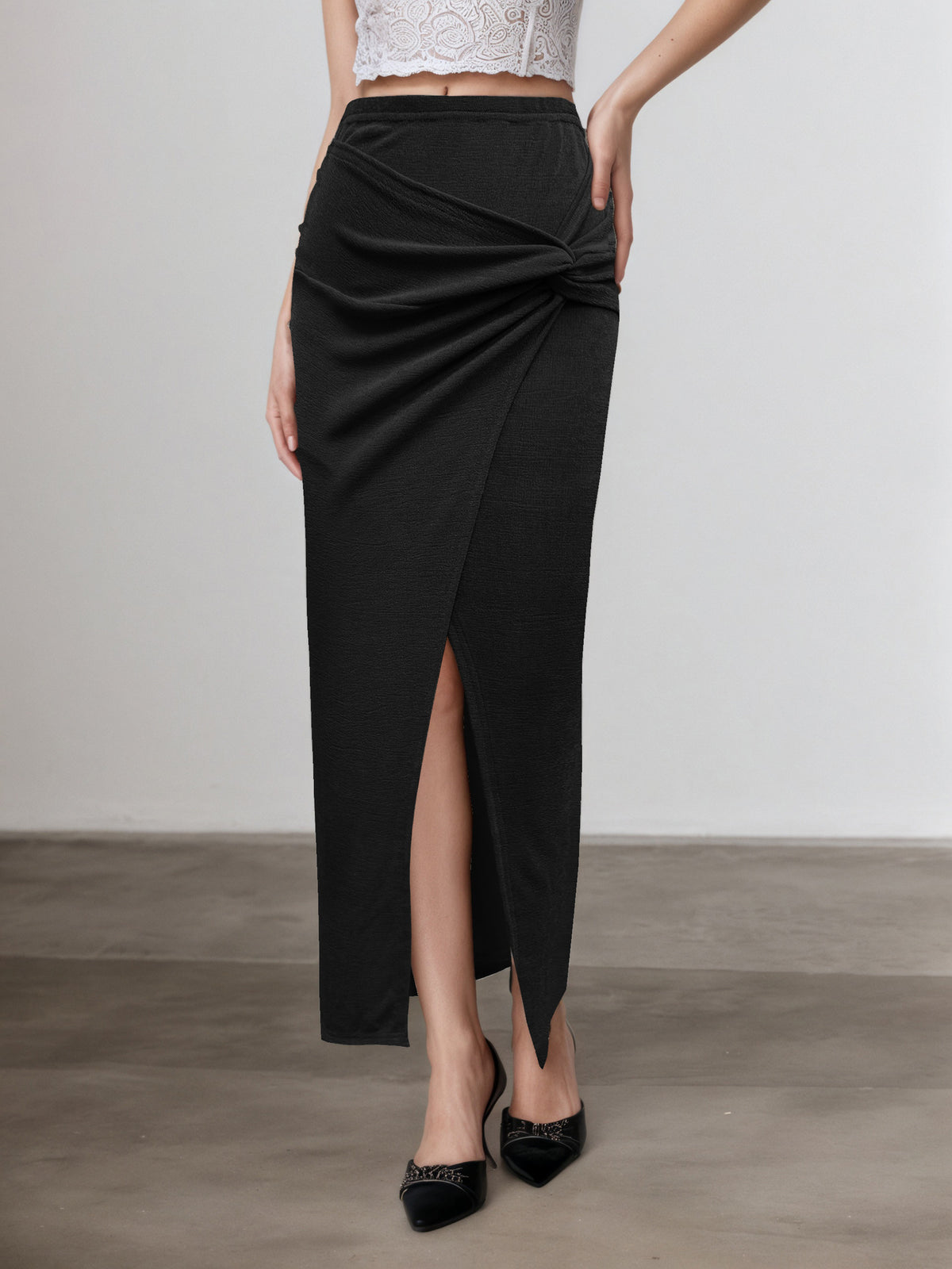 Black ruched knot-front maxi skirt, slit detail, versatile women’s evening skirt for rooftop drinks, travel outfits, and date night looks.