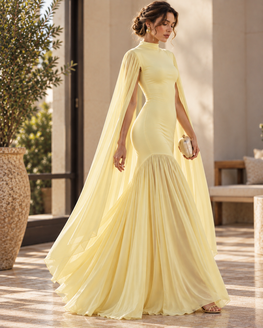 Women’s yellow cape sleeve evening gown with a fitted bodice, high neckline, flowing floor-length skirt and pleated drape, designed as an elegant formal dress for weddings, receptions and evening events.