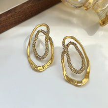 Load image into Gallery viewer, Gold sculptural double-oval statement earrings for women featuring pavé crystal accents, hypoallergenic metal, lightweight drop design, elegant modern jewelry USA.