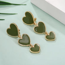 Load image into Gallery viewer, heart earrings, dangle heart shaped earrings, heart shaped clip on earrings, clip on earrings, dangle earrings, drop heart earrings, heart drop earrings, non pierced earrings, jewelry earrings, drop earrings, long earrings, party wear earrings, fun quirky earrings for women, olive gren heart earrings, best clip on earrings, clip on dangle earrings, michael kors heart earrings.