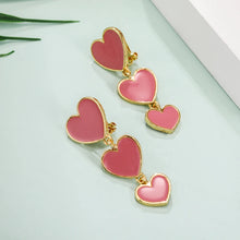 Load image into Gallery viewer, heart earrings, dangle heart shaped earrings, heart shaped clip on earrings, clip on earrings, dangle earrings, drop heart earrings, heart drop earrings, jewelry earrings, drop earrings, long earrings, party wear earrings, pink heart earrings, best clip on earrings, clip on dangle earrings, chanel clip on earrings.