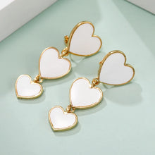 Load image into Gallery viewer, heart earrings, dangle heart shaped earrings, heart shaped clip on earrings, clip on earrings, dangle earrings, drop heart earrings, heart drop earrings, non pierced earrings, jewelry earrings, drop earrings, long earrings, party wear earrings, white heart earrings, clip on dangle earrings, chanel heart earrings.