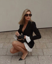 Load image into Gallery viewer, black and white mini dress, black and white blazer dress, Black mini dress with white ruffle hem, Old money chic dress with long sleeves, Elegant black and white mini dress for dinner date, Luxury monochrome dress for spring events, Long sleeve sheath fit dress with contrast details.
