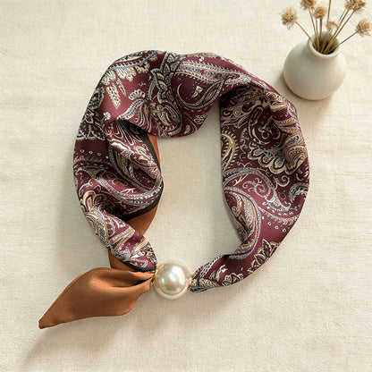Slim printed faux silk neck scarf featuring a smooth satin finish, botanical-inspired print, and oversized pearl magnetic closure for a refined women's fashion accessory.