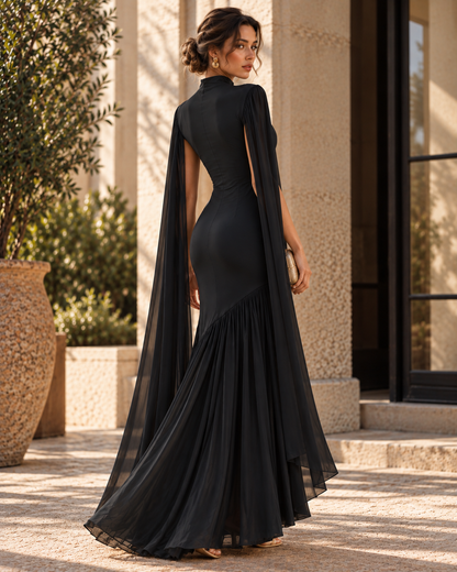 Black cape sleeve gown for women with a fit and flare silhouette, high neckline, fitted bodice and flowing pleated skirt, designed for formal wedding guest outfits, black-tie events and elegant evening receptions.