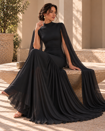 Black evening gown for women featuring cape sleeves, fitted waist, high neckline and asymmetrical pleated skirt, creating a graceful floor-length formal dress for black-tie events, weddings and evening receptions.