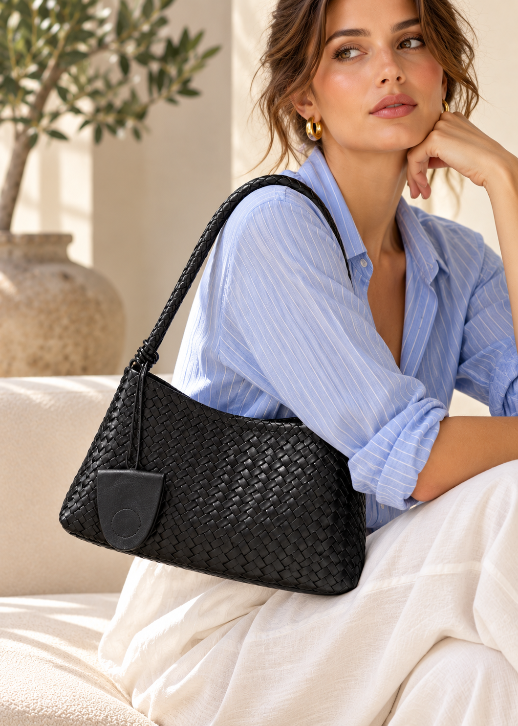 Black woven shoulder bag featuring a relaxed hobo shape, tactile basket weave construction, long braided strap and coordinating pouch, creating a contemporary textured handbag for workwear, weekends and everyday carry.
