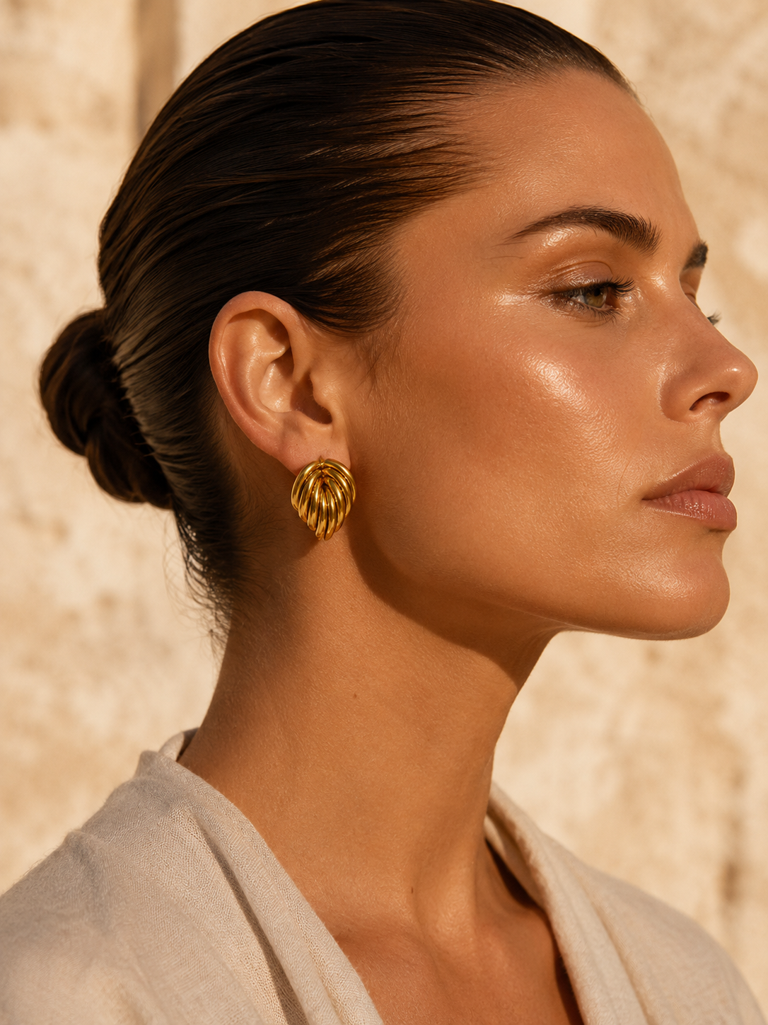 Chunky gold knot stud earrings with a sculptural multi-loop design and polished gold-tone finish for modern quiet luxury styling.