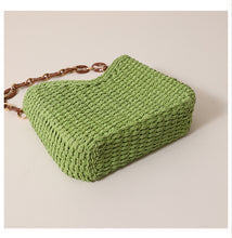 Load image into Gallery viewer, Compact woven straw bag with curved shape and resin chain strap, a lightweight straw shoulder bag designed for beach day bag outfits, summer outings, and relaxed vacation styling.