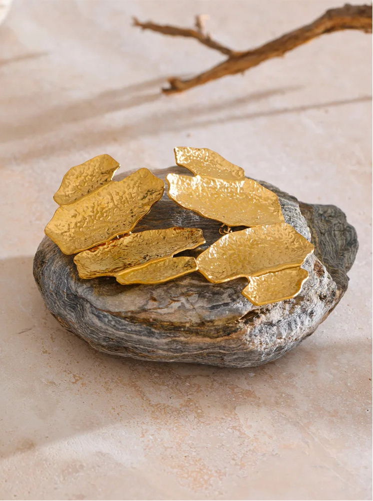 Designer-inspired hammered gold earrings with an artistic layered silhouette and textured gold-tone surface, styled as bold statement jewellery for wedding guests, date nights, capsule wardrobes and contemporary fashion collections.