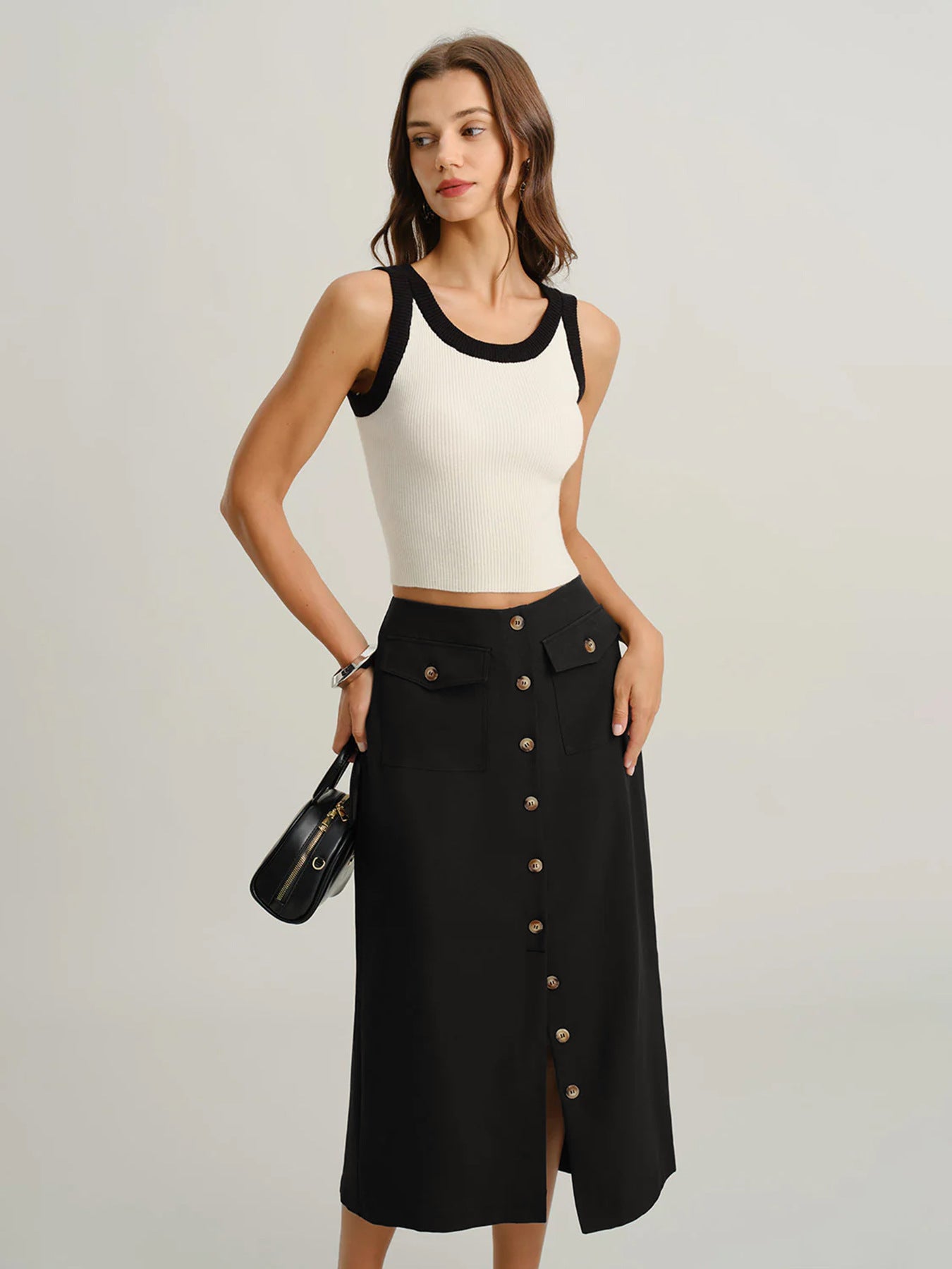 button front midi skirt, black pencil skirt midi, workwear midi skirt, High waisted black midi skirt, smooth structured texture with front button closure and flap pocket detail, body-skimming silhouette, button front midi skirt work outfit, ideal for office wear styling.
