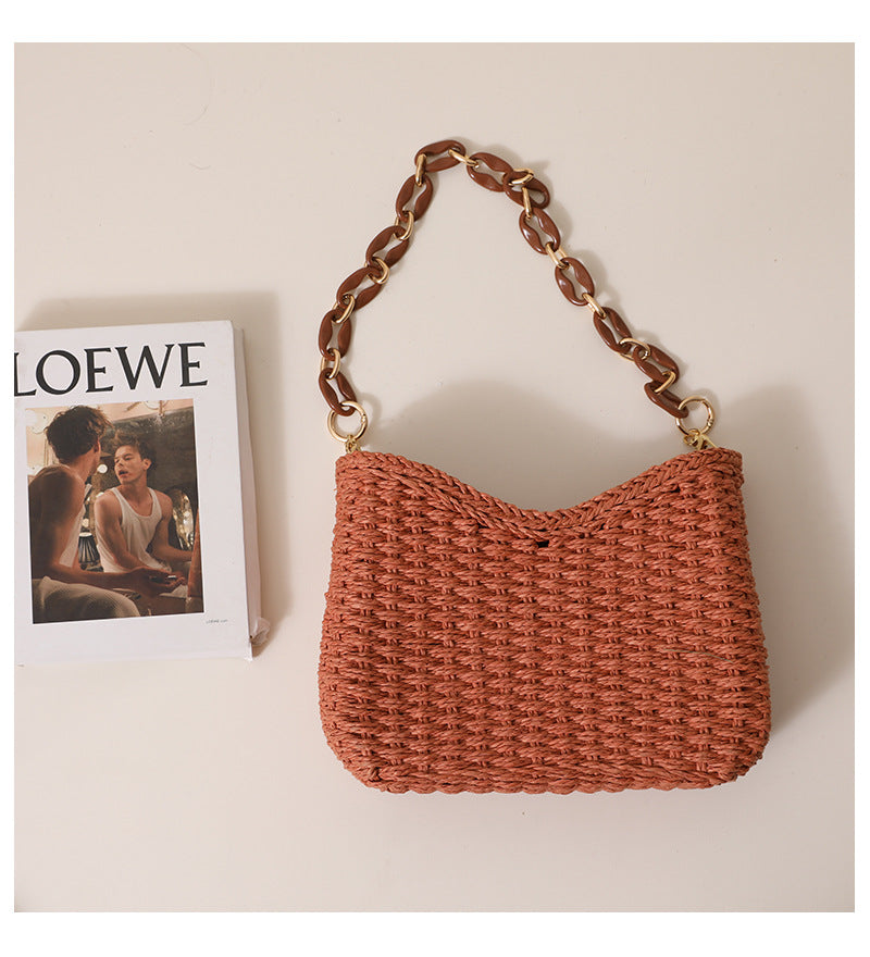 Natural woven straw handbag with structured silhouette and chunky chain strap, a chic women's straw bag perfect for resort wear outfits and effortless casual summer purse styling.