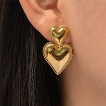 Load image into Gallery viewer, heart drop earrings, Heart earrings, heart dangle earrings, dangle earrings, gold fashion jewelry, uirky earrings for women, Chic earrings for women, Statement earrings, everyday jewelry, Modern fashion earrings, Elegant jewelry for women, Fun fashion jewelry, Women’s statement earrings, Quirky jewelry, Everyday earrings, Gold and silver earrings, Playful earrings, Chic statement jewelry, Unique women’s earrings.