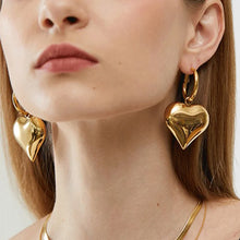 Load image into Gallery viewer, heart drop earrings, Heart earrings, heart dangle earrings, dangle earrings, gold fashion jewelery, huggie hoop earrings, Heart huggie hoop earrings,  Asymmetric earrings for women, Quirky earrings for women, Chic earrings for women, Statement earrings, everyday jewelry, Modern fashion earrings, Elegant jewelry for women, Fun fashion jewelry, Women’s statement earrings, Quirky jewelry