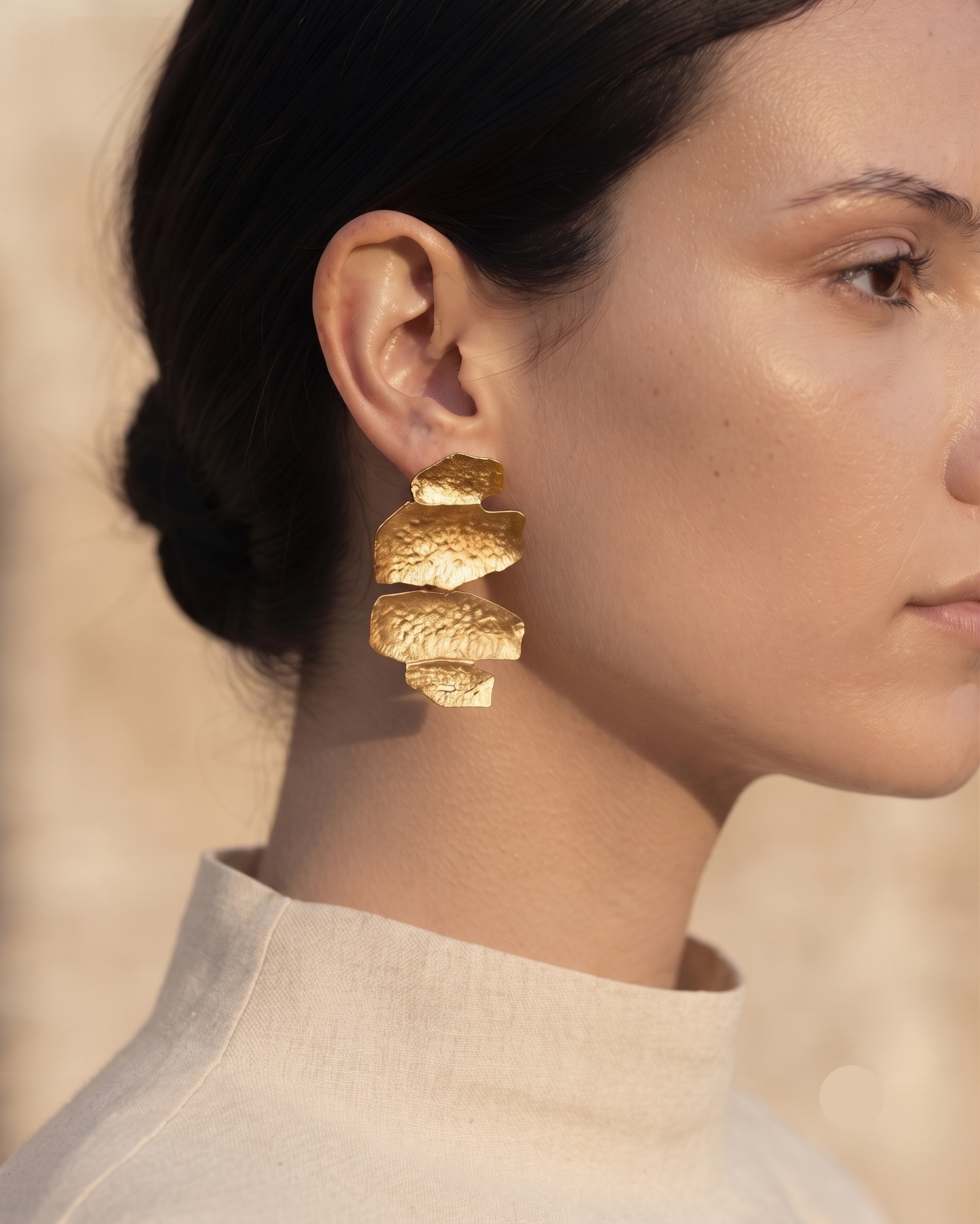 Textured gold statement drop earrings with an abstract sculptural shape and hammered finish, creating a bold contemporary accessory that complements linen outfits, tailored workwear, occasion dresses and minimalist wardrobes.