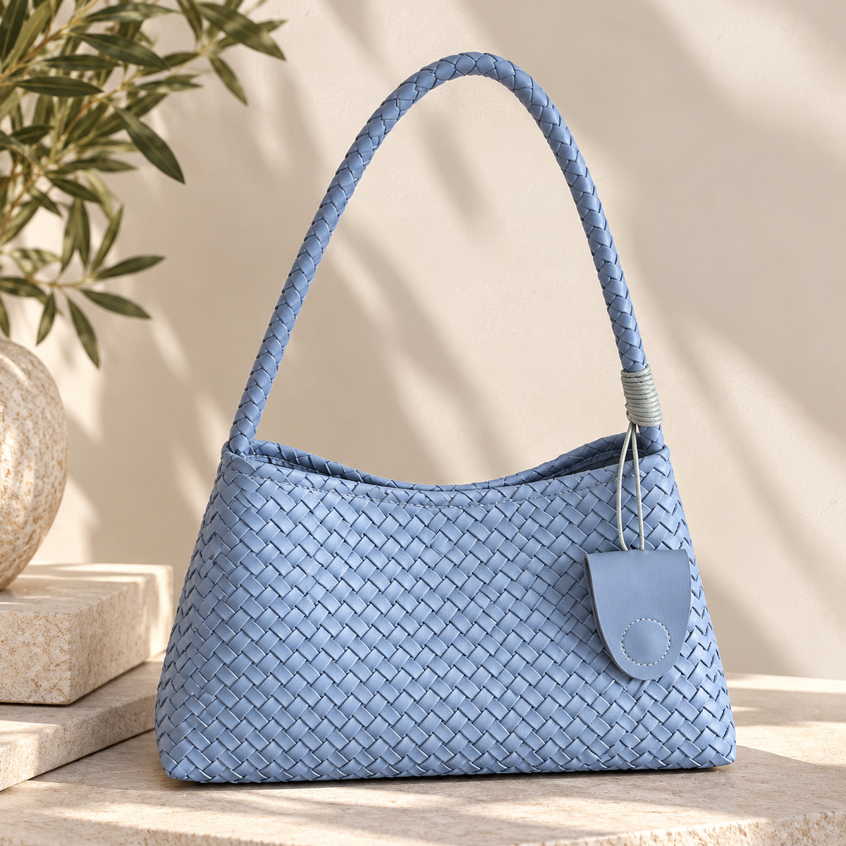 Textured woven shoulder hobo handbag for women with a curved relaxed shape, woven basket construction, long braided shoulder strap and matching zip pouch, designed as a modern shoulder bag for blazers, dresses, workwear and weekend outfits.