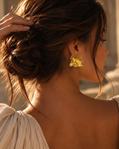 Women's gold wavy stud earrings with an abstract square shape, sculpted folds and reflective stainless steel surface, combining organic geometric jewelry with statement metal accessories for weekend brunch, date nights and special occasions.