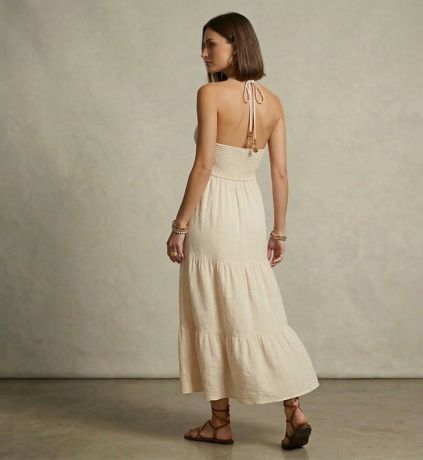 Open back halter tiered maxi in beige lightweight woven fabric, bohemian maxi dress with smocked waistband and tiered skirt silhouette for beach vacation tiered maxi dress looks.