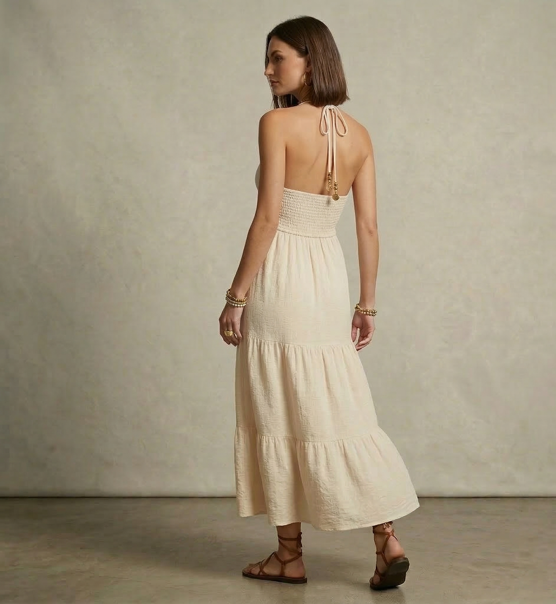 Open back halter tiered maxi in beige lightweight woven fabric, bohemian maxi dress with smocked waistband and tiered skirt silhouette for beach vacation tiered maxi dress looks.