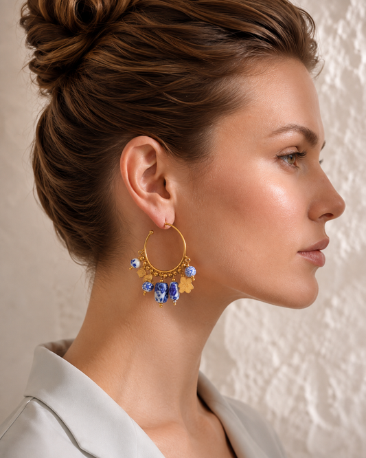 Women's ceramic drop earrings with blue and white porcelain-inspired beads, PVD real gold plating and a statement hoop silhouette, designed as elegant gold drop earrings for women looking for distinctive everyday fashion jewellery.