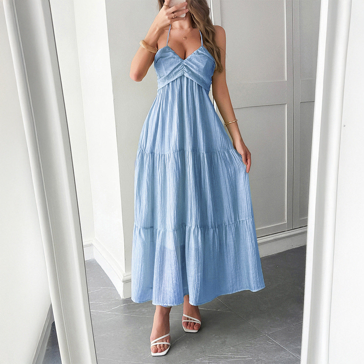 Model wearing ruffle-trimmed maxi dress with halter neckline – styled for resort chic vacation moments.