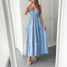 Load image into Gallery viewer, Model wearing ruffle-trimmed maxi dress with halter neckline – styled for resort chic vacation moments.