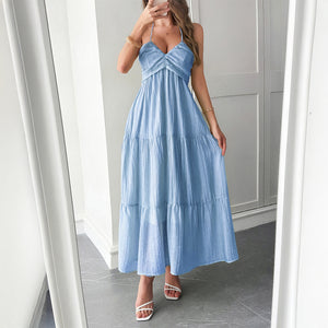 Model wearing ruffle-trimmed maxi dress with halter neckline – styled for resort chic vacation moments.