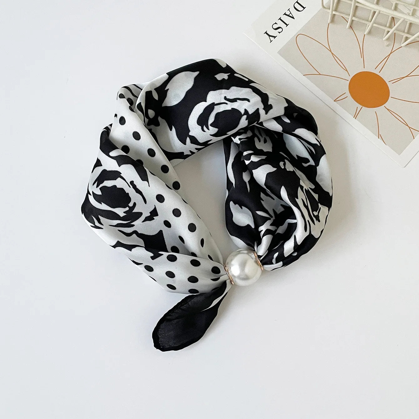 Slim printed faux silk neck scarf featuring a smooth satin finish, botanical-inspired print, and oversized pearl magnetic closure for a refined women's fashion accessory.