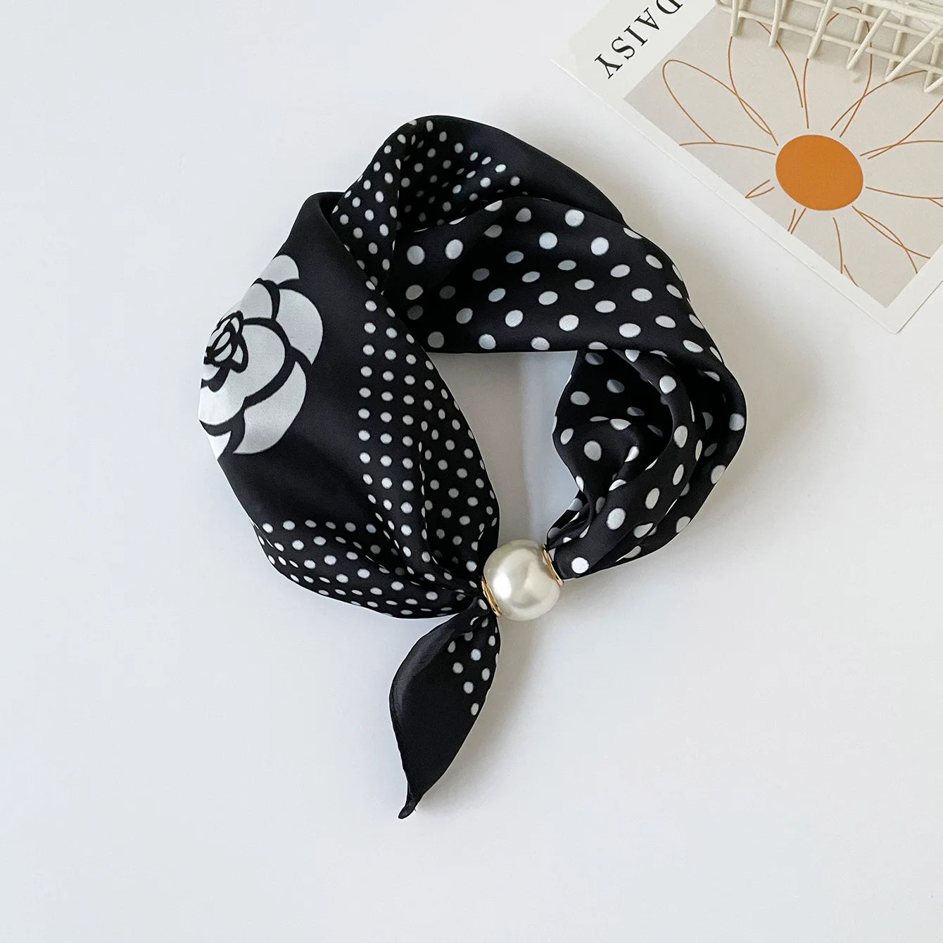 Women's printed silk-feel neck scarf with a pearl magnetic closure, styled as a quiet luxury accessory that complements neutral tailoring, trench coats, and timeless capsule wardrobes.
