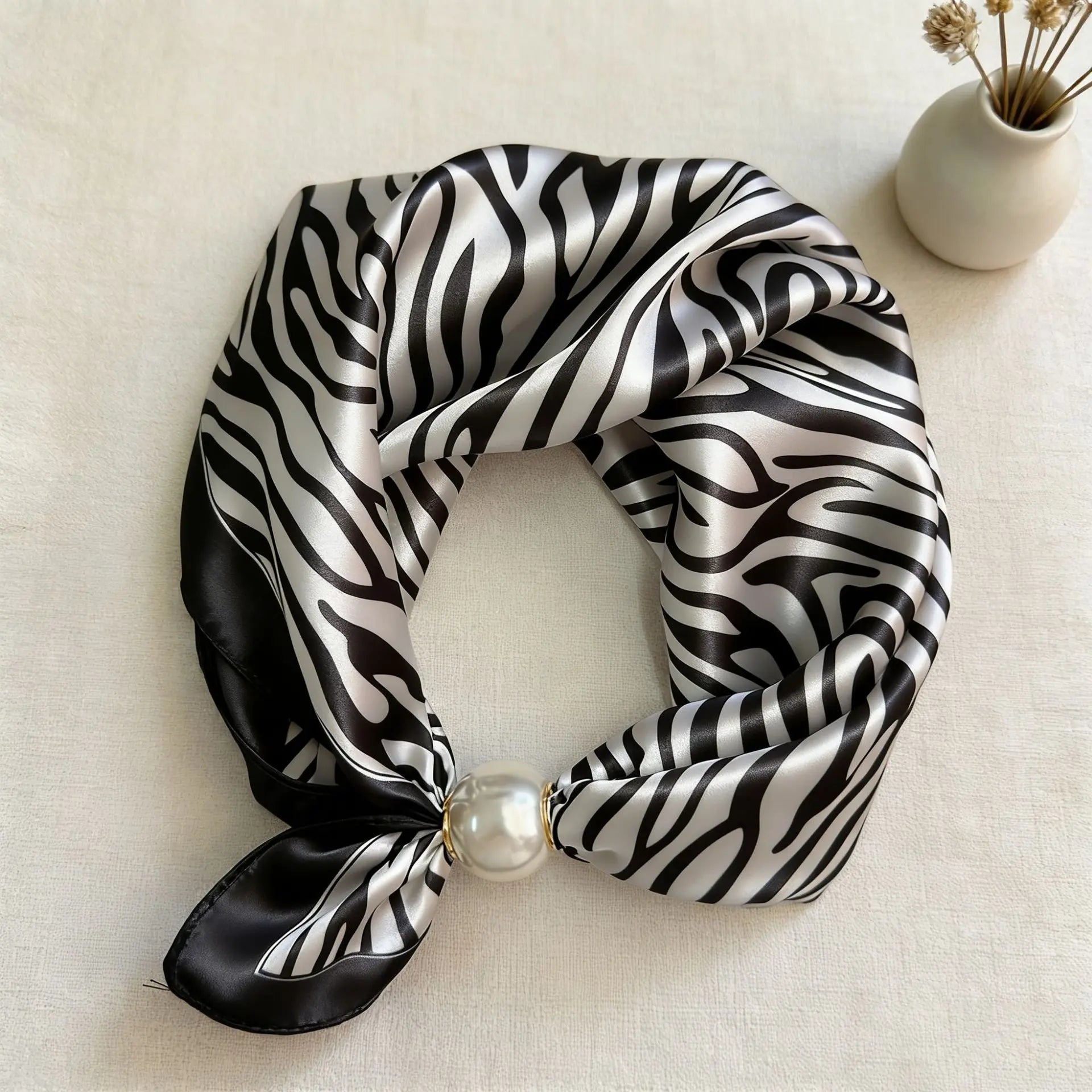 Slim printed faux silk neck scarf featuring a smooth satin finish, botanical-inspired print, and oversized pearl magnetic closure for a refined women's fashion accessory.