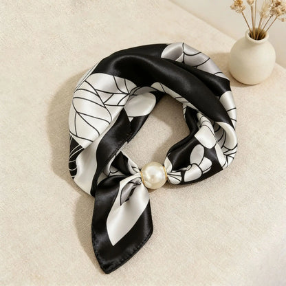 Women's printed silk-feel neck scarf with a pearl magnetic closure, styled as a quiet luxury accessory that complements neutral tailoring, trench coats, and timeless capsule wardrobes.