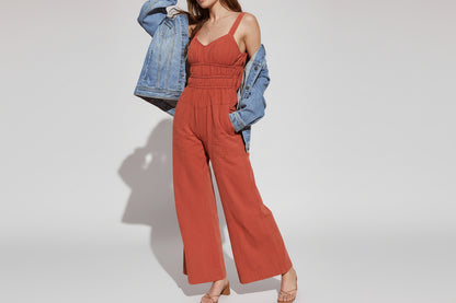 rust smocked waist jumpsuit, vacation V-neck smocked jumpsuit, earth tone jumpsuit, quiet luxury jumpsuit, Open back tie smocked jumpsuit, Smocked waistband jumpsuit, Vacation wide leg jumpsuit, summer brunch jumpsuit, warm weather flowy jumpsuit.