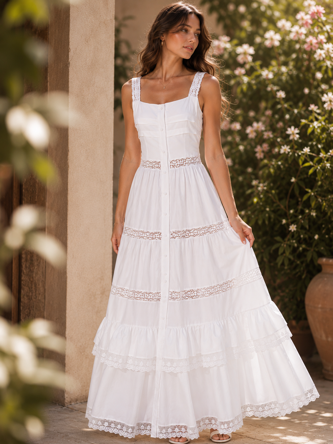 White lace maxi dress with a fit and flare silhouette, tiered white dress for summer, structured corset bodice, lace waist insert, flowing gathered tiers, and scalloped trim, styled as a garden wedding guest dress for outdoor ceremonies and reception celebrations.
