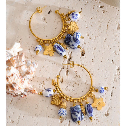 Gold plated ceramic statement earrings featuring a drop hoop silhouette and porcelain-inspired beadwork, ideal for brunch outfits, garden parties and elevated summer occasion styling.