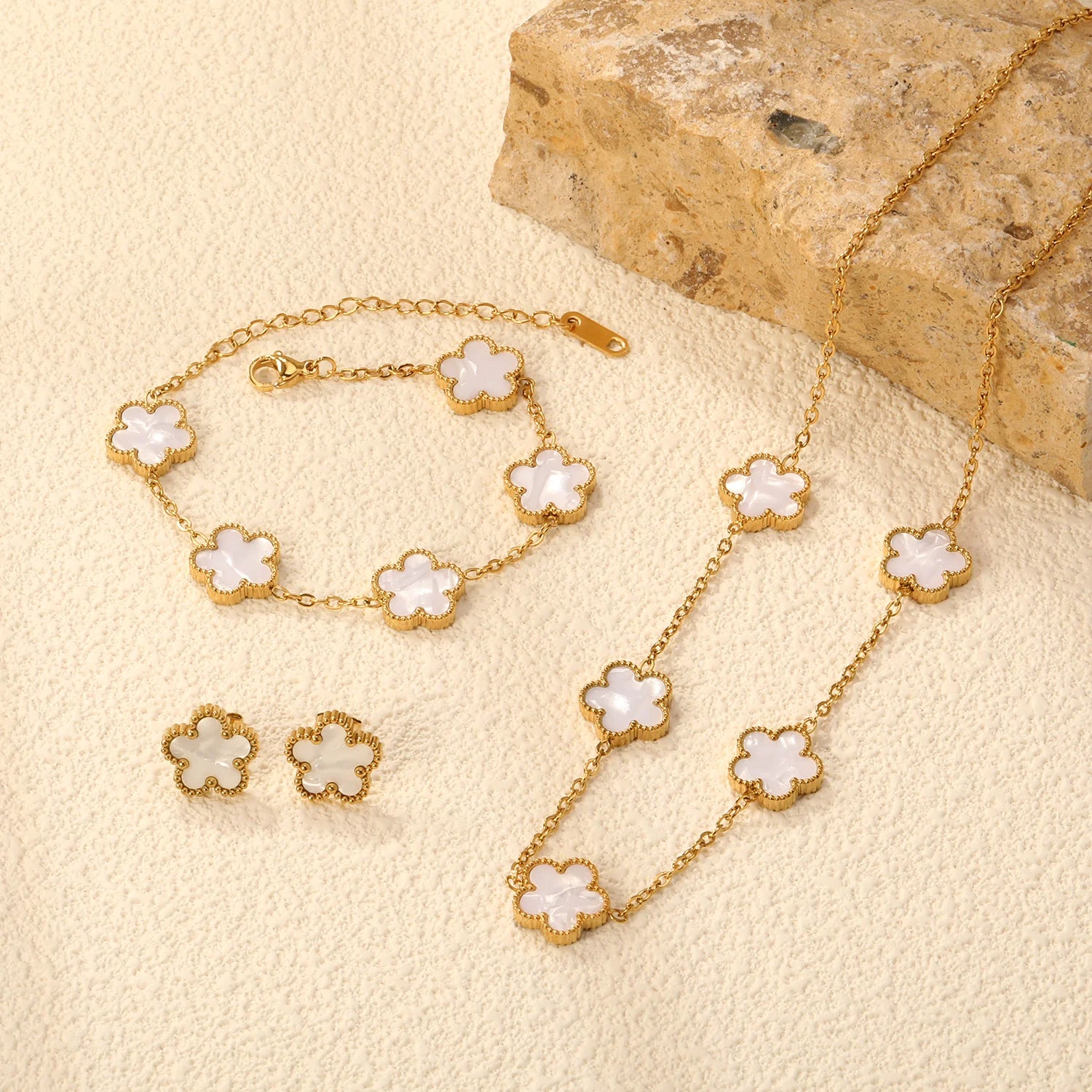 clover necklace bracelet earrings set, floral jewelry set, everyday jewelry set, old money jewelry aesthetic, Minimalist jewelry set for women, polished gold-tone charm texture with dainty gold jewelry set styling, symmetrical clover layout, minimalist clover necklace bracelet earrings set, business casual accessories.