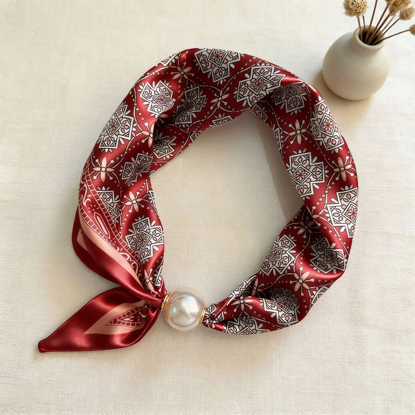 Slim printed faux silk neck scarf featuring a smooth satin finish, botanical-inspired print, and oversized pearl magnetic closure for a refined women's fashion accessory.