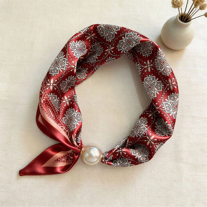 Slim printed faux silk neck scarf featuring a smooth satin finish, botanical-inspired print, and oversized pearl magnetic closure for a refined women's fashion accessory.