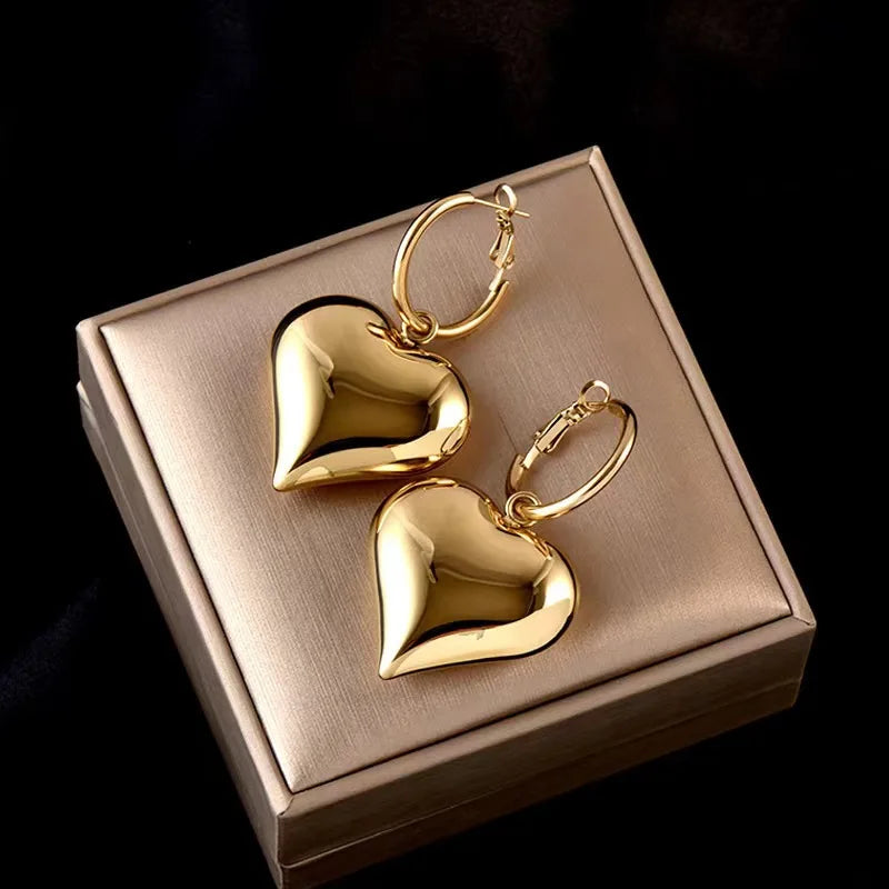 drop heart earrings, gold heart earrings, Asymmetric earrings for women, Quirky earrings for women, Chic earrings for women, Statement earrings, everyday jewelry, Modern fashion earrings, Elegant jewelry for women, Fun fashion jewelry, Women’s statement earrings, Quirky jewelry.
