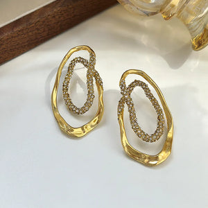 Gold sculptural double-oval statement earrings for women featuring pavé crystal accents, hypoallergenic metal, lightweight drop design, elegant modern jewelry USA.