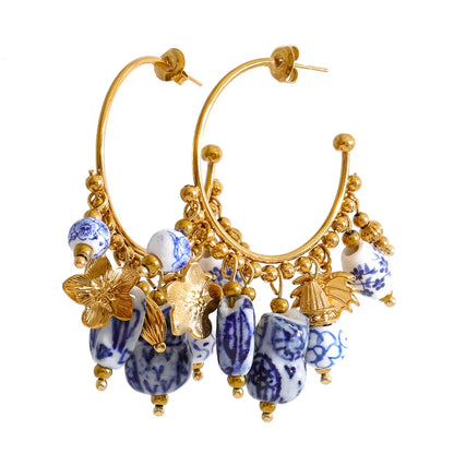 Gold plated ceramic drop earrings with an open hoop silhouette and decorative charm details, perfect for wedding guest outfits, destination celebrations and sophisticated brunch styling.