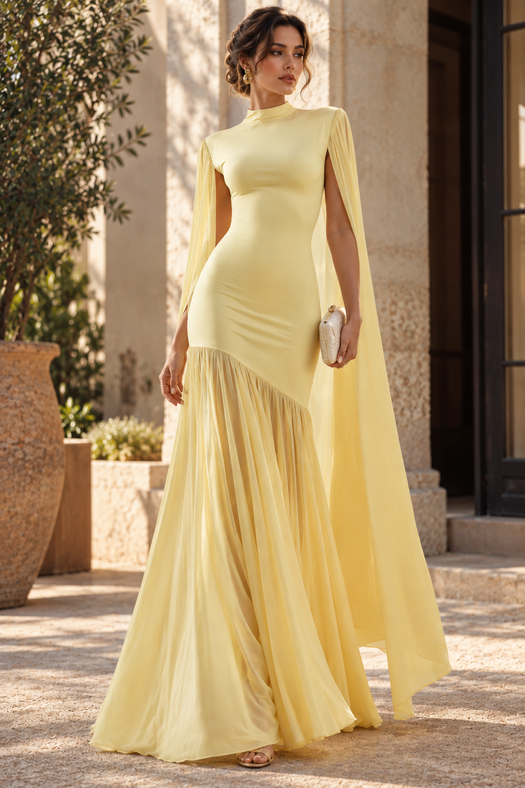 Women’s yellow floor-length formal dress with a sculpted fit and flare silhouette, high neck, elongated cape sleeves and flowing pleated skirt for weddings, galas and black-tie occasions.