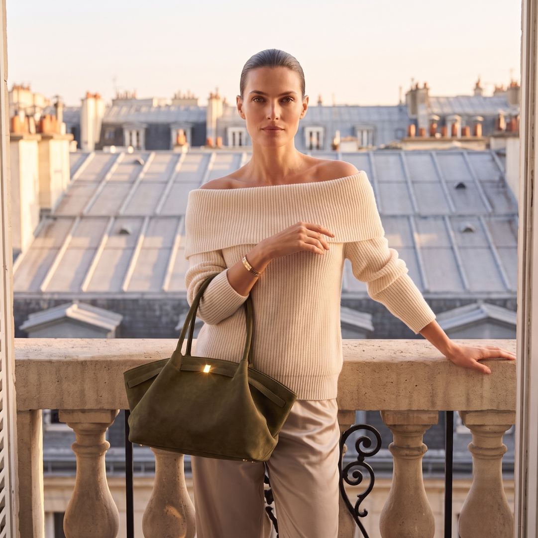 Faux suede tote bag featuring a roomy oversized quiet luxury airport tote silhouette, belted trim detailing, gold-tone hardware, and open interior for stylish travel and everyday wear.