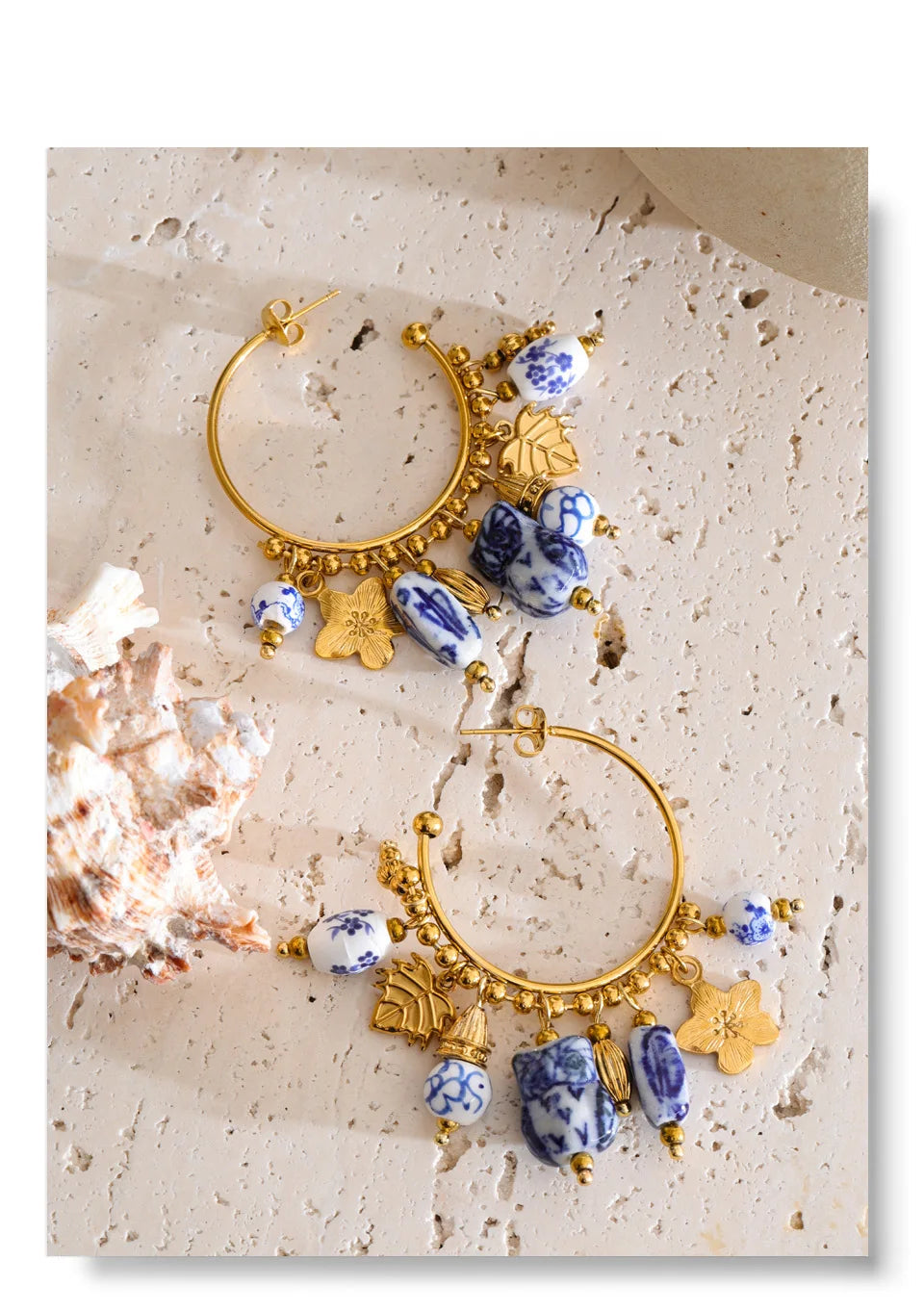 Statement gold hoop earrings with ceramic bead drops, floral charm accents and a porcelain-inspired colour palette, created for women building a resort wear, coastal chic and vacation jewellery collection.