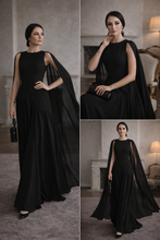 Load image into Gallery viewer, black elevated statement piece maxi gown, ruched long maxi dress gown, cape maxi dress, asymmetric evening gown, evening party dress with ruched waist and drape cut, Asymmetric cape maxi, fit and flare gown, sculptural maxi with timeless silhouette,  opaque torso vs. fluid chiffon cape for structured top/fluid bottom.
