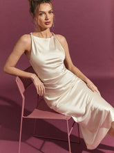 Load image into Gallery viewer, evening party dress, date night satin dress, cocktail satin dress, classy satin dress, Satin ivory midi dress with glossy finish and tailored waist detail, designed for women seeking elegant wedding guest outfits, holiday party dresses, and chic evening looks.