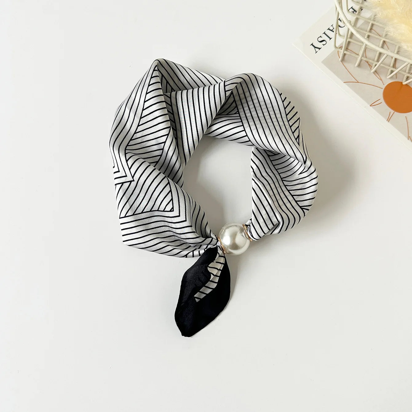Slim printed faux silk neck scarf featuring a smooth satin finish, botanical-inspired print, and oversized pearl magnetic closure for a refined women's fashion accessory.