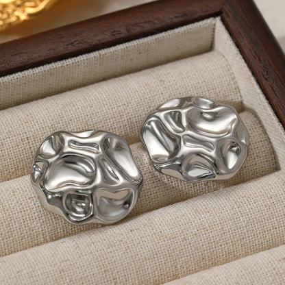 Textured metal statement stud earrings in silver, bold abstract design with high-shine finish, contemporary women’s fashion jewelry for workwear and special occasions.