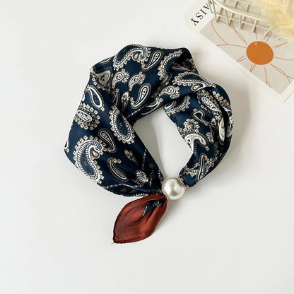 Slim printed faux silk neck scarf featuring a smooth satin finish, botanical-inspired print, and oversized pearl magnetic closure for a refined women's fashion accessory.