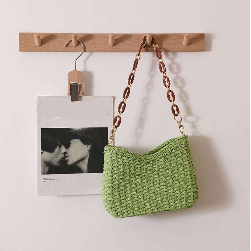 Chic woven straw bag with curved shoulder silhouette and statement chain strap, a stylish women's straw bag that works as a resort bag women love for summer outings and vacation styling, straw sling beach bag, wicker purse, resort bag.